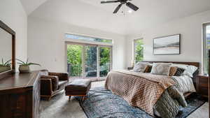 Carpeted bedroom featuring access to outside, multiple windows, and ceiling fan