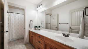 Bathroom with double vanity and tile patterned flooring