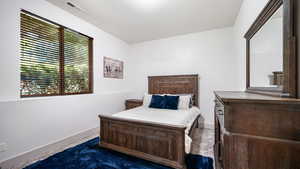 Bedroom featuring dark colored carpet and baseboards