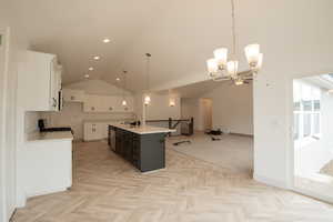 Kitchen featuring appliances with stainless steel finishes, a chandelier, a sink, open floor plan, and white cabinetry