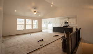 Living area with a ceiling fan, high vaulted ceiling, and recessed lighting