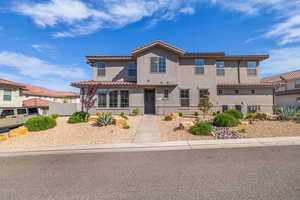 View of front of house with stucco siding and a tile roof