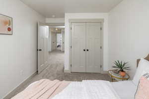 Bedroom with carpet, a closet, and baseboards
