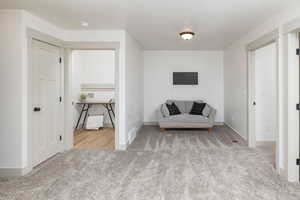 Living area featuring carpet flooring and baseboards