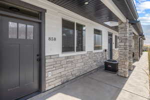 Entrance to property with central AC and stone siding