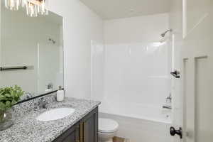 Bathroom featuring shower / tub combination, toilet, and vanity
