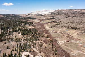Aerial view of property and surrounding area featuring a mountainous background