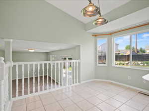 Spare room featuring tile patterned floors and baseboards