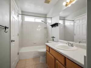 Full bathroom with vanity, toilet, tile patterned floors, and shower / bath combination