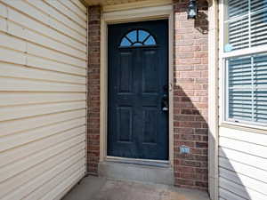 Doorway to property with brick siding