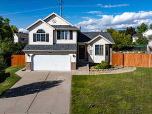 View of front facade featuring an attached garage, driveway, brick siding, and a shingled roof