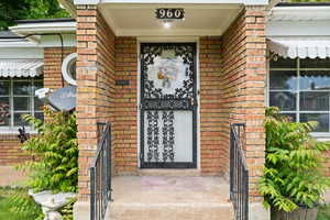 Entrance to property with brick siding and covered porch