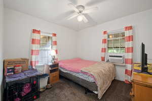 Carpeted bedroom featuring cooling unit and ceiling fan