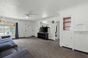 Living room featuring carpet flooring, a ceiling fan, and baseboards