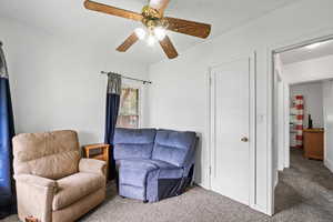 Sitting room featuring carpet floors and a ceiling fan