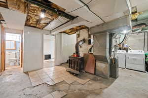 Below grade area with washer and dryer, a wood stove, and heating unit