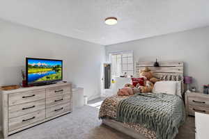 Bedroom featuring carpet flooring and a textured ceiling