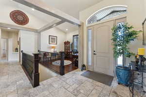 Entrance foyer with stone tile floors, lofted ceiling, and recessed lighting