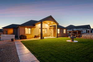 Rear view of house featuring stucco siding, a patio area, and a shingled roof