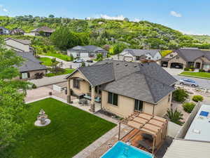 Back of house with stucco siding, roof with shingles, a residential view, and a patio area