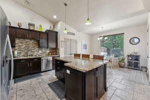 Kitchen featuring appliances with stainless steel finishes, stone tile flooring, tasteful backsplash, a chandelier, and recessed lighting