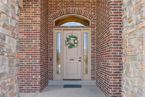 View of exterior entry featuring brick siding