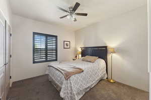 Carpeted bedroom featuring ceiling fan