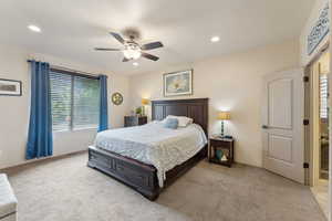 Bedroom featuring light colored carpet, ceiling fan, and recessed lighting