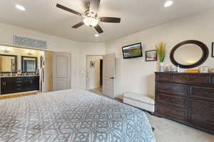 Bedroom featuring light carpet, recessed lighting, ensuite bath, and ceiling fan