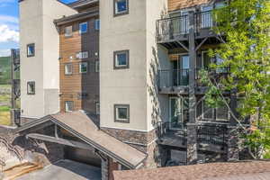 View of apartment building / complex featuring asphalt driveway and an attached garage