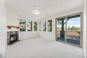 Unfurnished sunroom featuring carpet floors, healthy amount of natural light, and baseboards