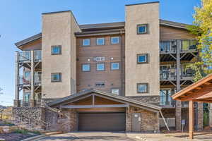 View of apartment building / complex with concrete driveway and an attached garage
