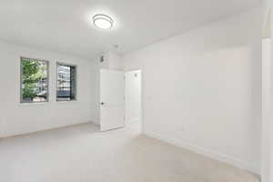 Spare room with light colored carpet and baseboards