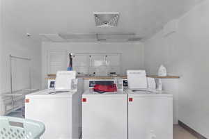 Shared laundry room with washer and dryer, attic access, and tile patterned flooring