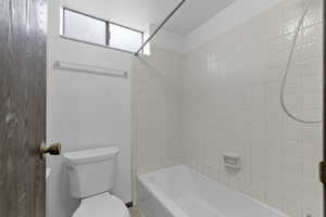 Bathroom featuring toilet and washtub / shower combination