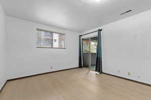 Spare room featuring light wood-type flooring and baseboards