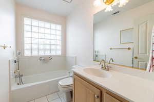 Full bathroom with a bath, vanity, toilet, and tile patterned flooring