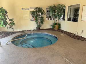 View of swimming pool featuring a hot tub