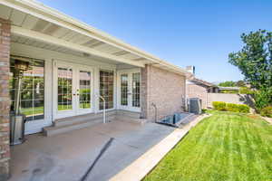 View of yard with french doors, a patio, and cooling unit