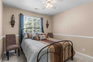 Bedroom with light carpet, baseboards, and a ceiling fan