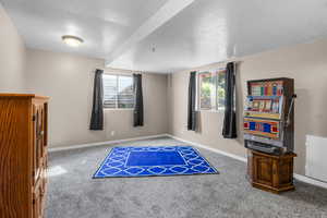 Interior space with carpet flooring, a textured ceiling, and baseboards