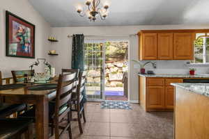 Dining space featuring a chandelier, healthy amount of natural light, and light tile patterned floors