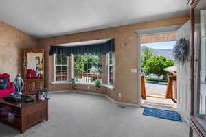 Foyer entrance with carpet floors, a textured ceiling, and baseboards