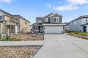 Craftsman-style house featuring concrete driveway, stone siding, and an attached garage