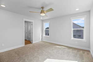 Unfurnished bedroom with carpet floors, baseboards, recessed lighting, ensuite bathroom, and a ceiling fan