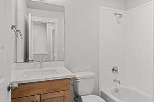 Full bath featuring toilet, vanity, and  shower combination