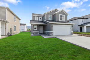 View of front of house featuring stucco siding, stone siding, concrete driveway, an attached garage, and a front yard