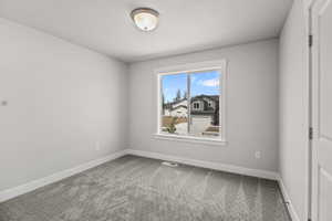Unfurnished room featuring baseboards and carpet
