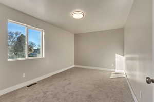 Carpeted spare room with baseboards