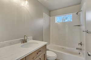 Bathroom featuring toilet, vanity, and shower / bathtub combination